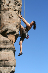 woman climber ascending rock face
