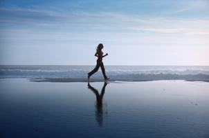 woman running at waters edge on beach